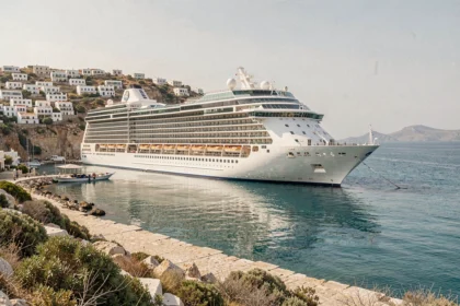 Paquebot de croisière ancré dans un port grec avec maisons blanches et mer Égée turquoise