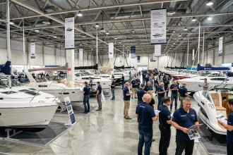Vue panoramique de l'intérieur du Salon Nautique International de Paris avec des bateaux exposés et des visiteurs